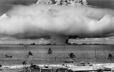 grayscale photo of explosion on the beach