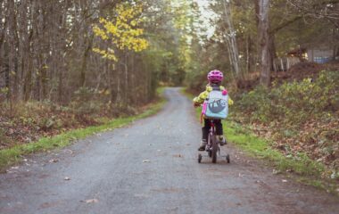 toddler riding bicycle on road