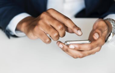 man in black suit holding smartphone