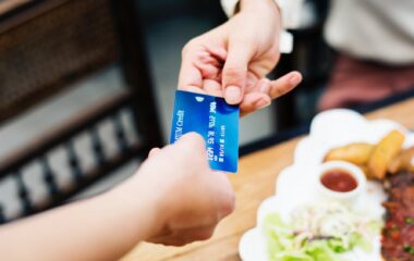 two person holding credit card closeup photo