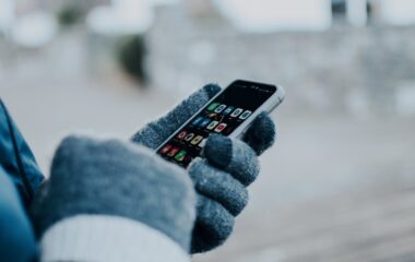 person wearing gloves holding a cellphone