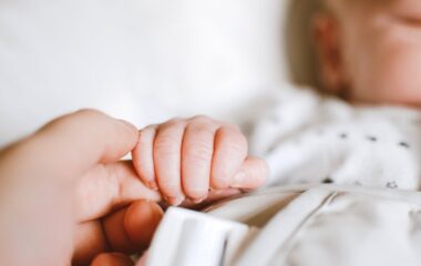 person holding baby s hand