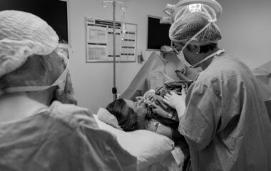 grayscale photo of woman lying on hospital bed