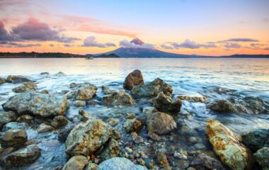 brown and gray rocks on seashore during sunset