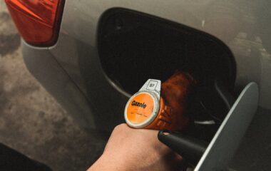 person refilling gasoline on gas tank