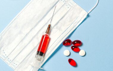 syringe and pills on blue background