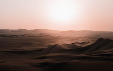 scenery of car riding over desert dunes