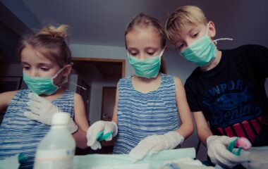 three children wearing face masks