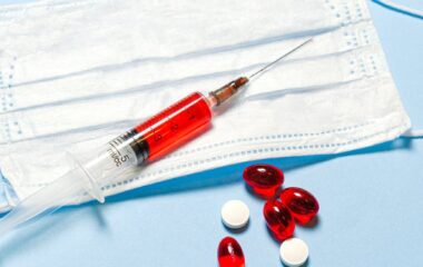 syringe and pills on blue background