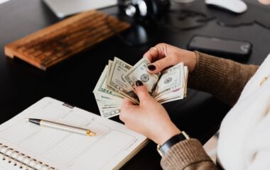 crop woman counting money at modern office table