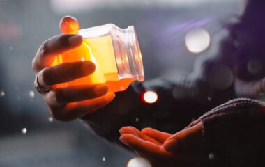 person about to pour yellow liquid on palm