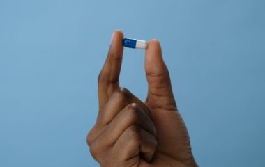 a person holding a blue and white pill