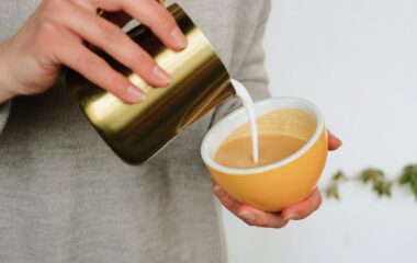 a person holding a cup of coffee with milk